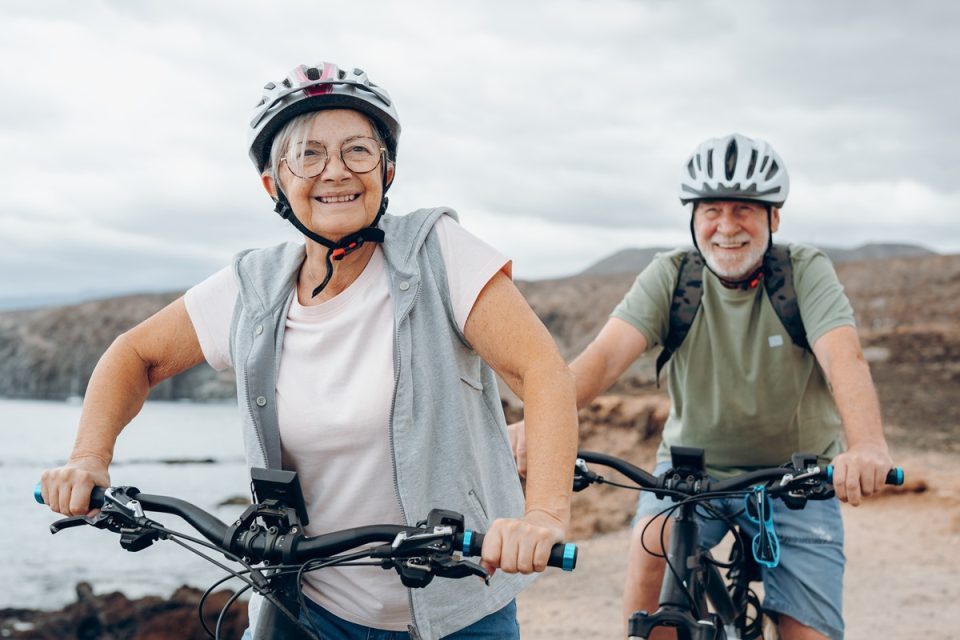 A retired couple taking a bike ride in the countryside.