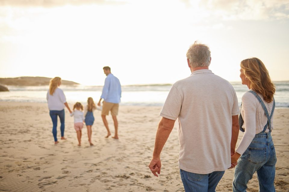 A family walks together on the beach.