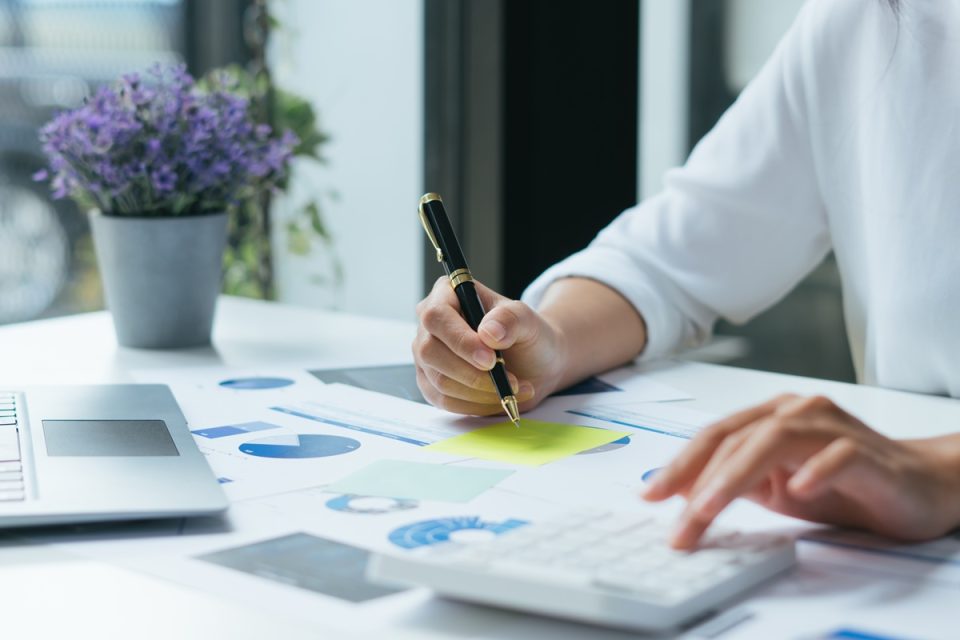 A businessman working with a pen and calculator.